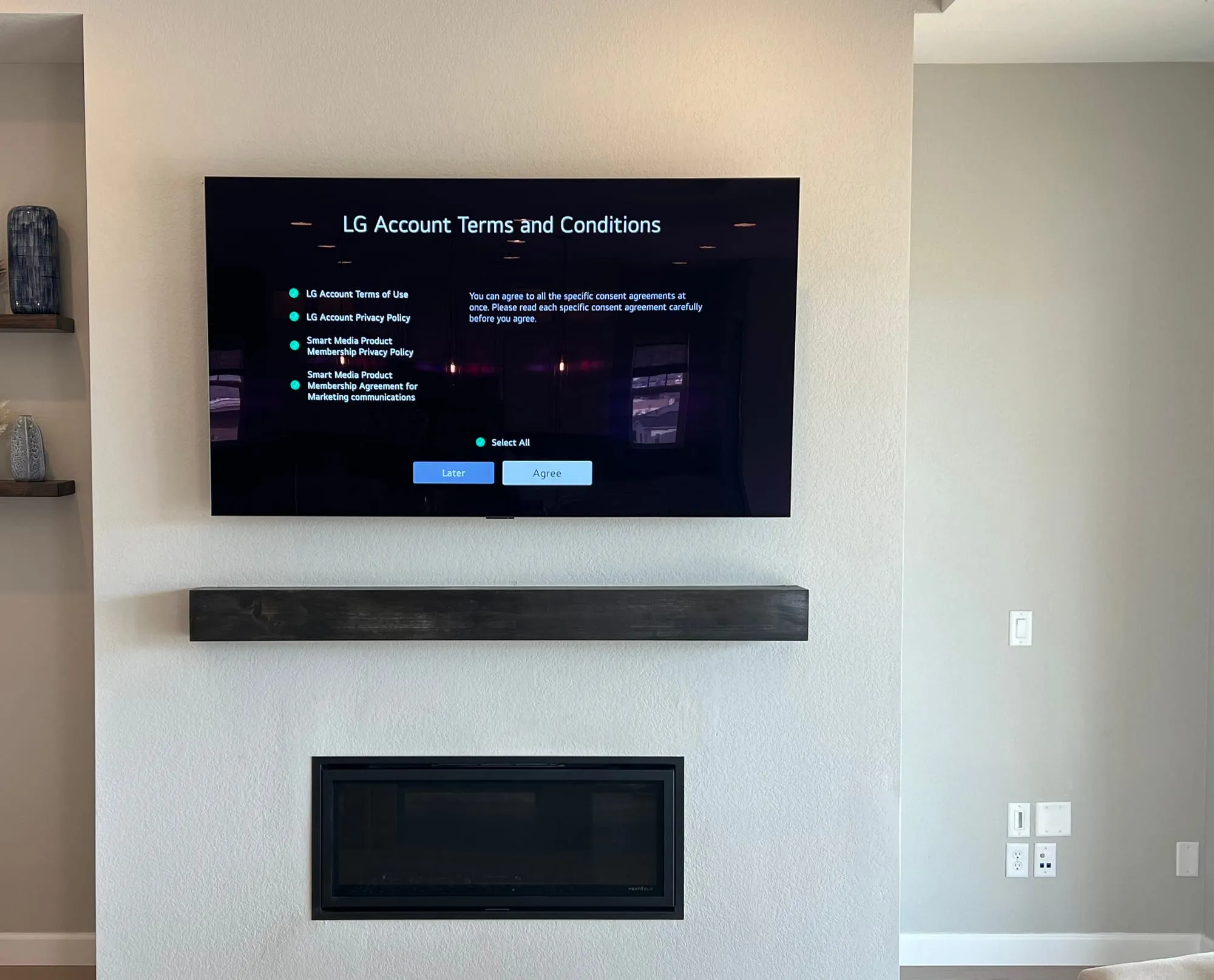 TV mounted above a floating wood mantel with concealed wiring