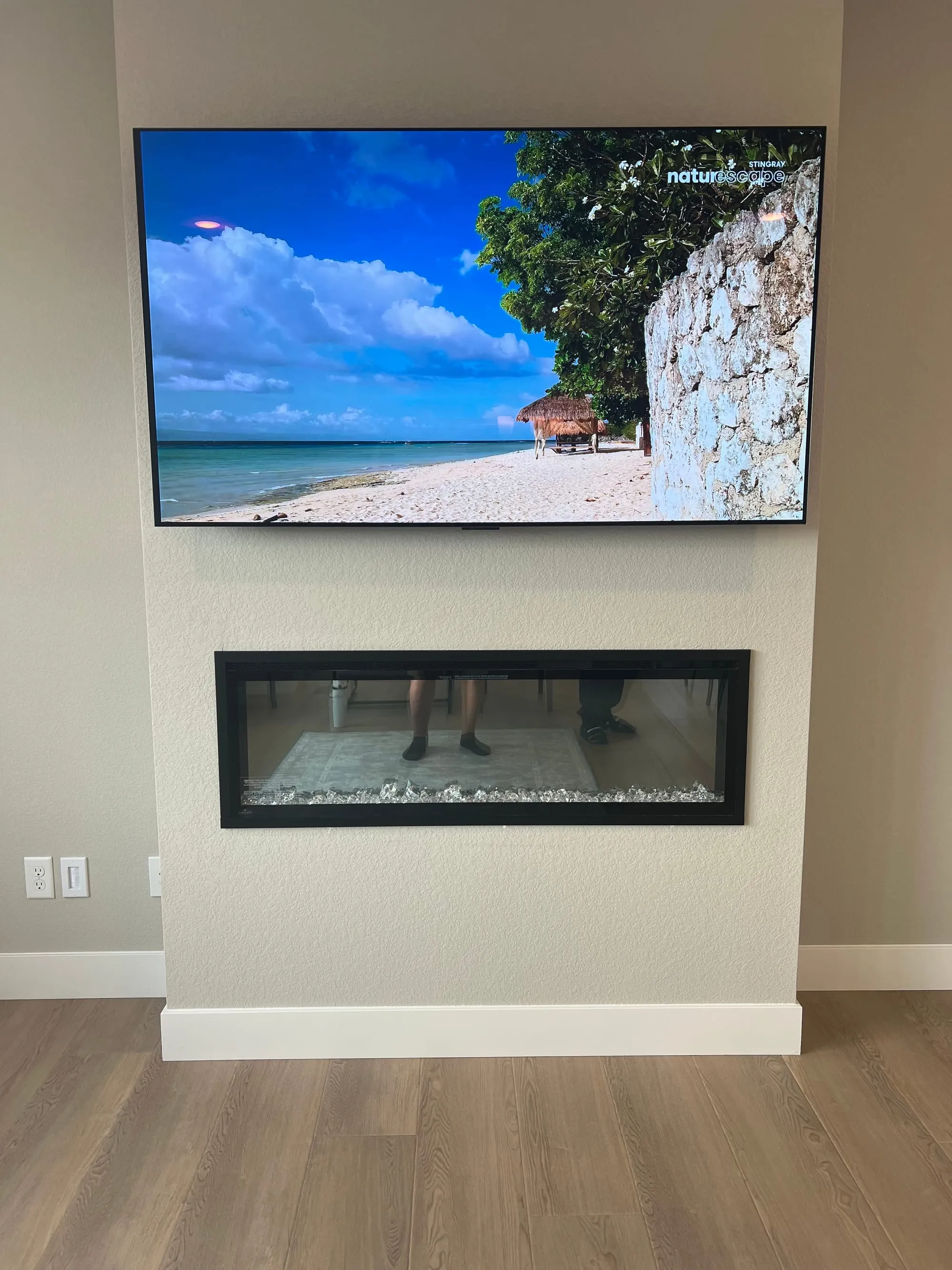 TV mounted above a linear fireplace with the wiring run inside the wall